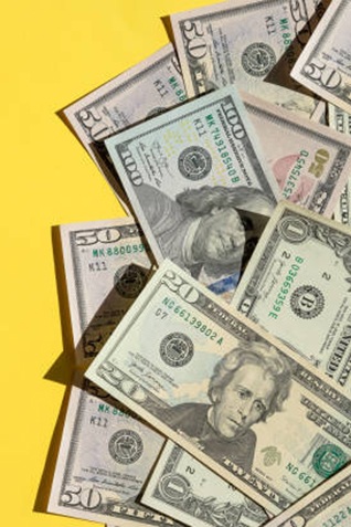 Cash spread out on yellow background
