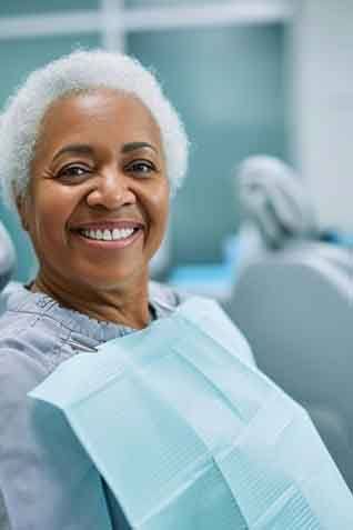 a patient smiling after receiving her new dental implants