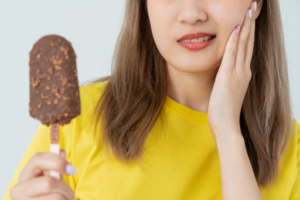 Close up of woman trying to eat ice cream with sensitive teeth